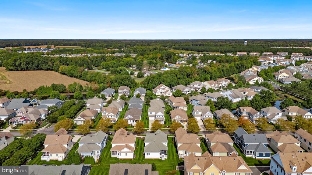 Aerial view of a suburban neighborhood beside wooded fields.