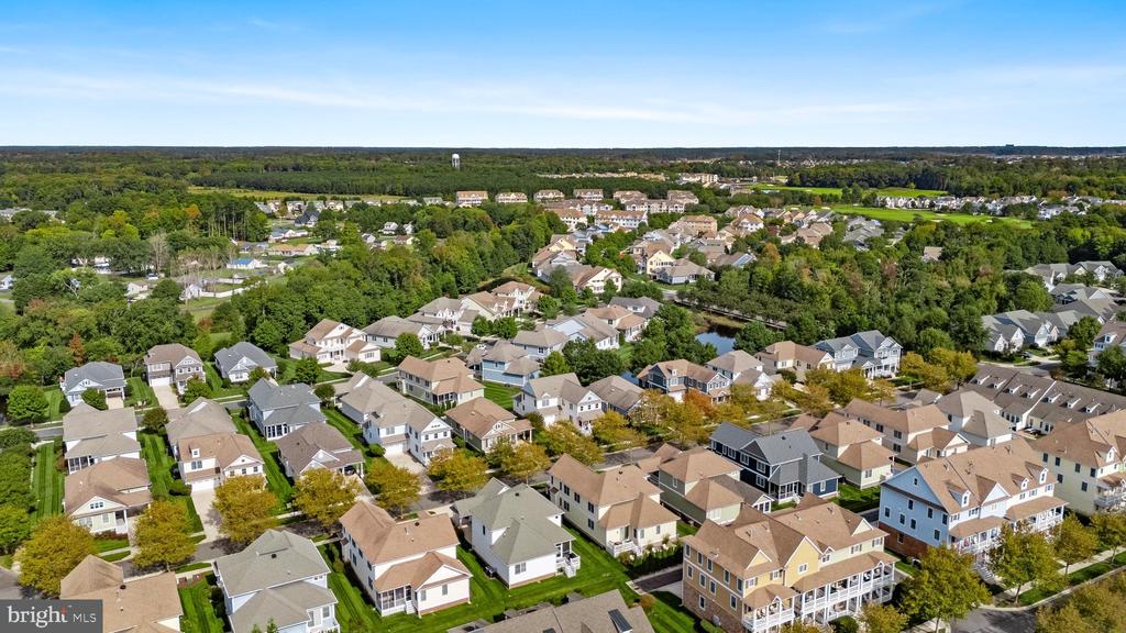 Aerial view of a residential neighborhood with tree-lined streets and rows of homes.