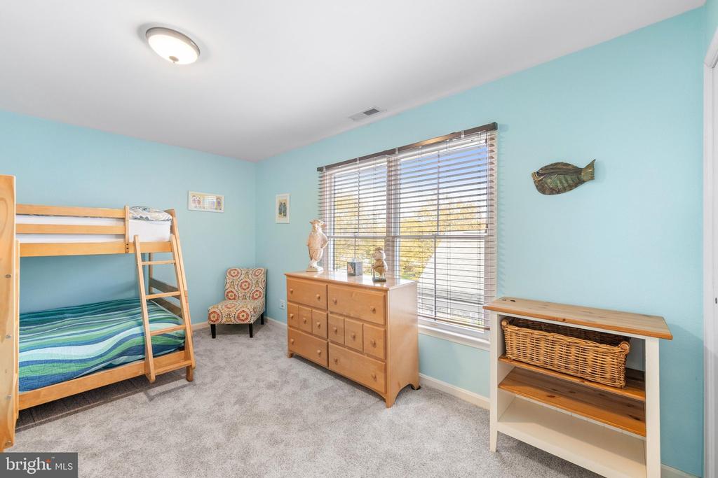 Bedroom with a wooden bunk bed, aqua walls, and a large window with blinds.
