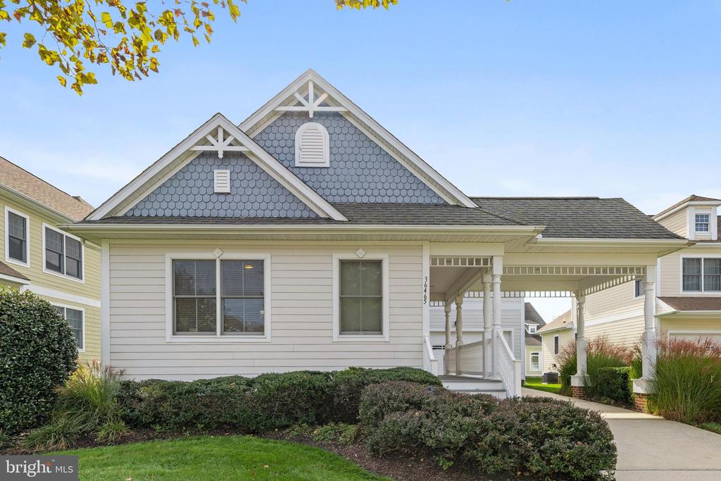 Detached home with blue shingle gables, white siding, and a covered side walkway.