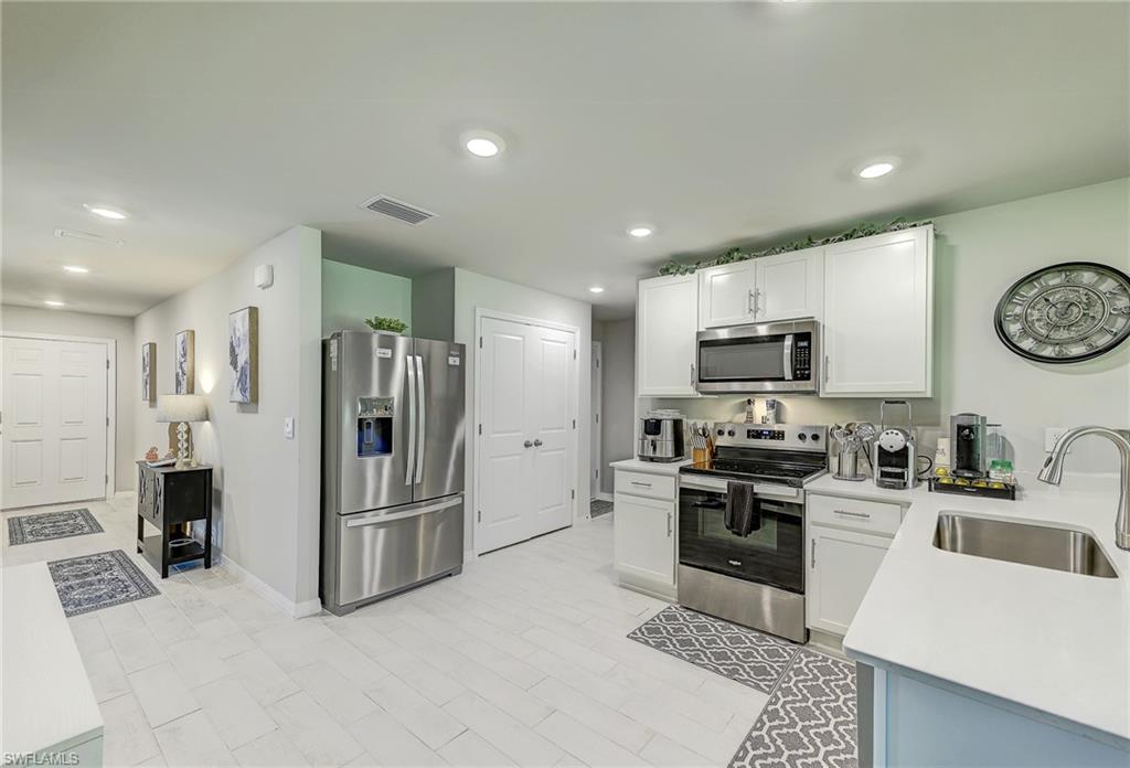 Kitchen with white cabinets, stainless-steel appliances, and a sink peninsula.