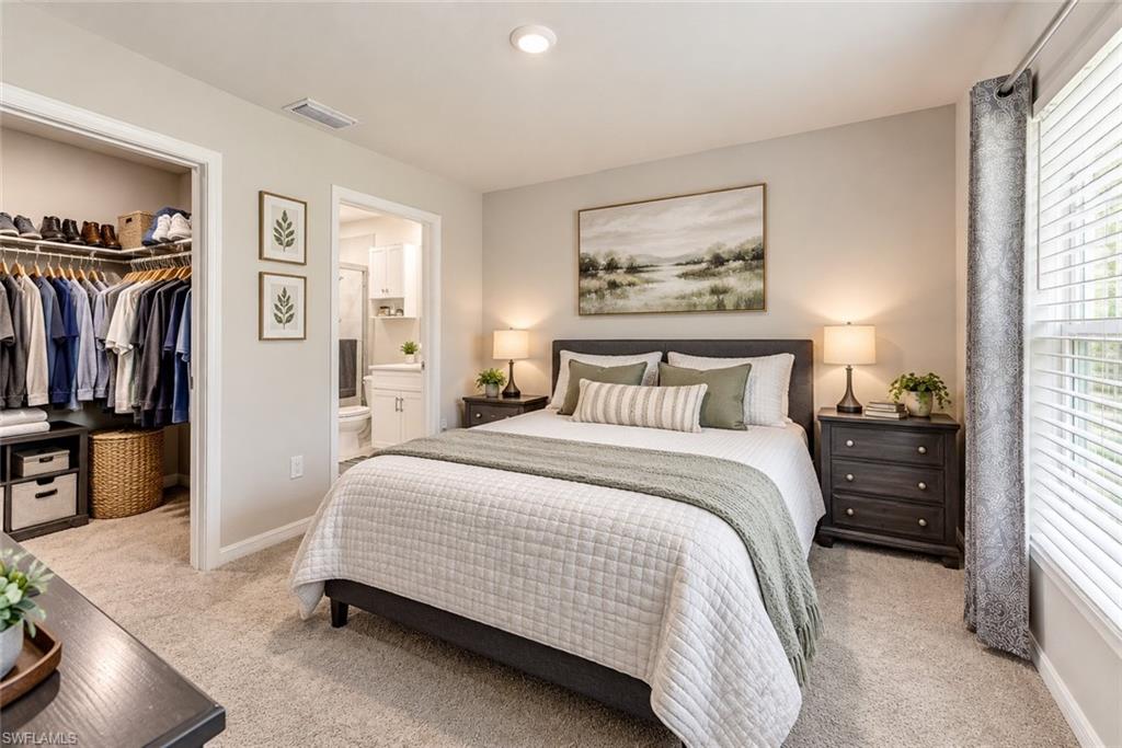Bedroom with a large bed, walk-in closet, and doorway to an ensuite bathroom.