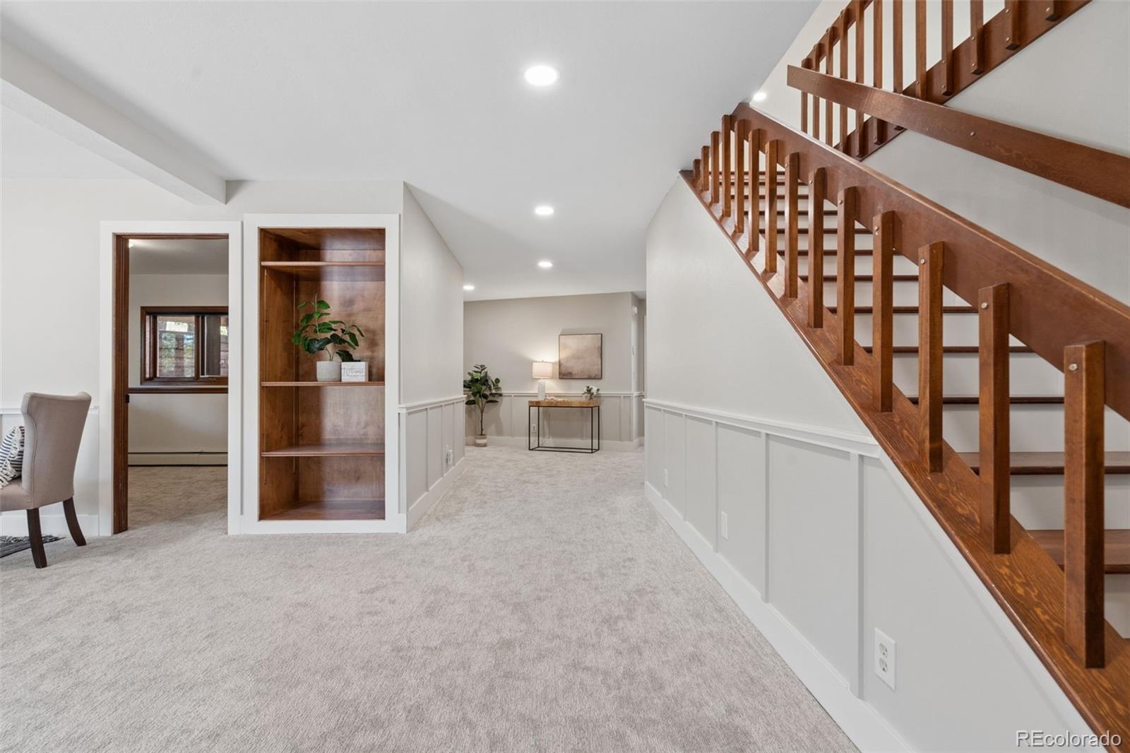 Carpeted landing with a dark wood staircase, built-in shelves, and a console table.