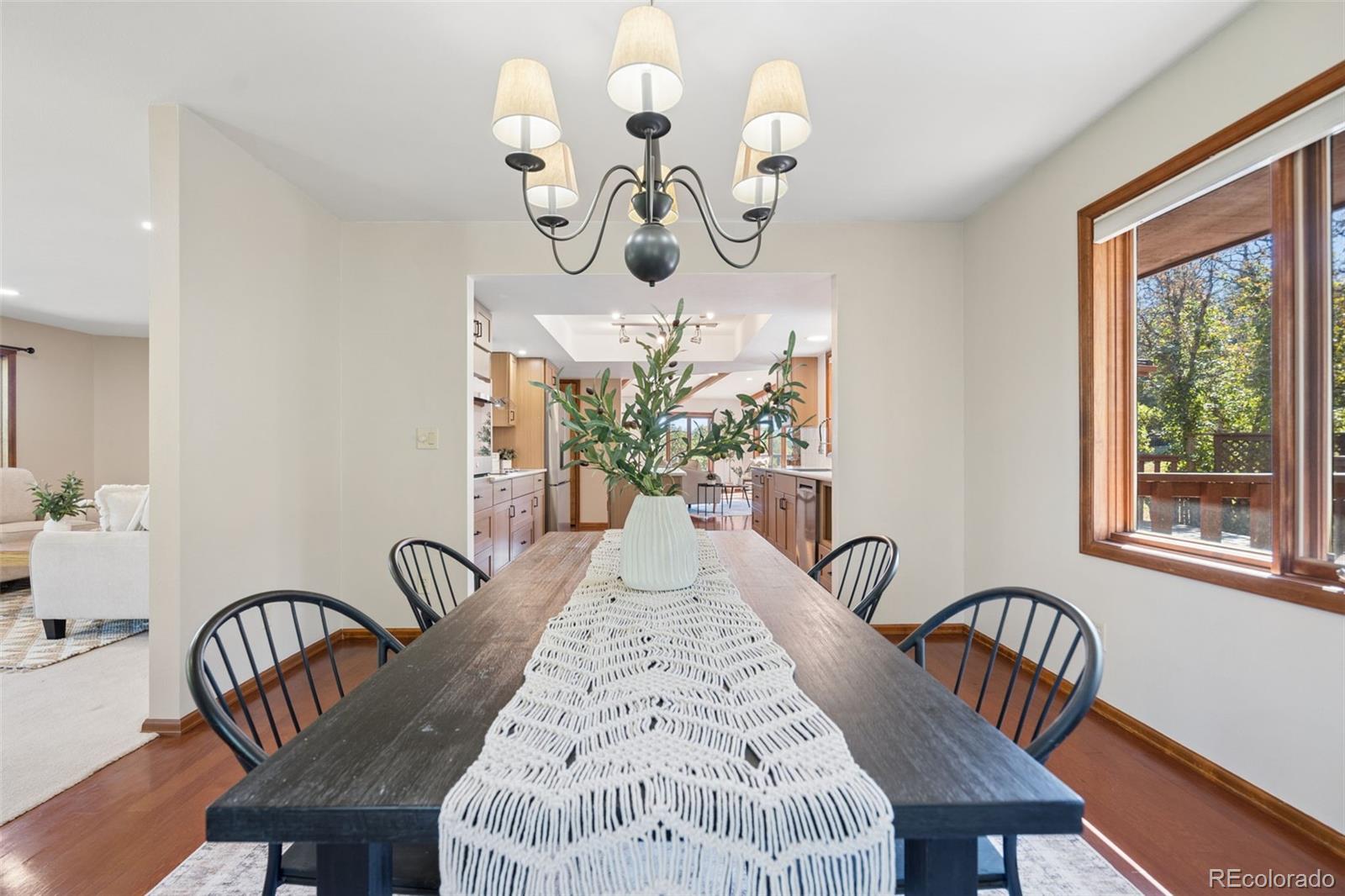 Dining room with a dark wood table, black chairs, and a view through to the kitchen.