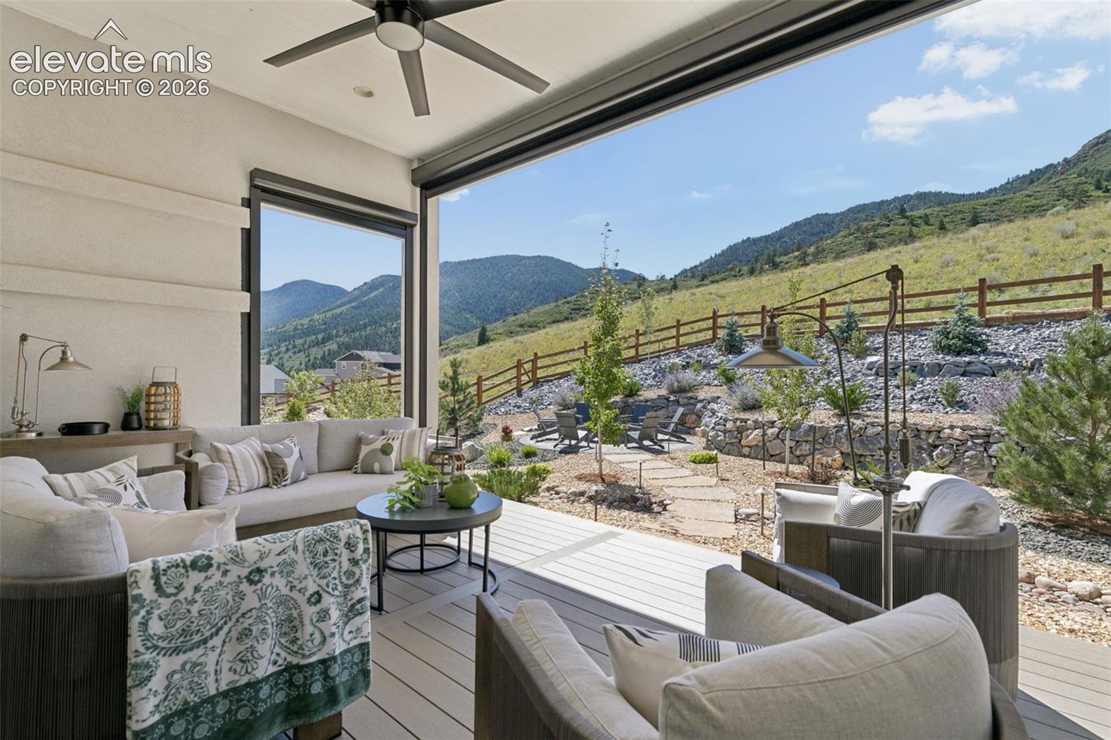 Furnished covered patio opening to a landscaped yard and mountain views.