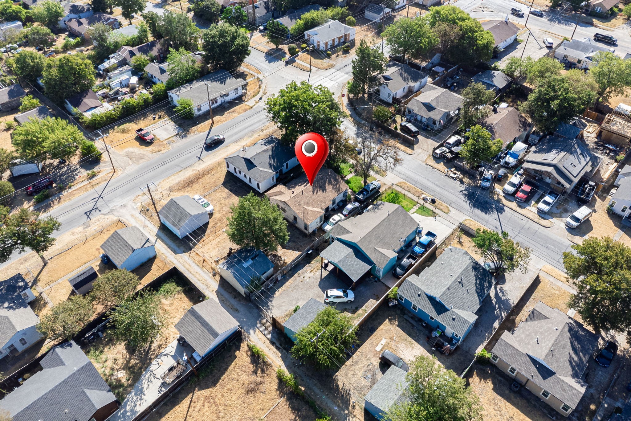 Aerial view of the marked house among neighborhood homes and streets.