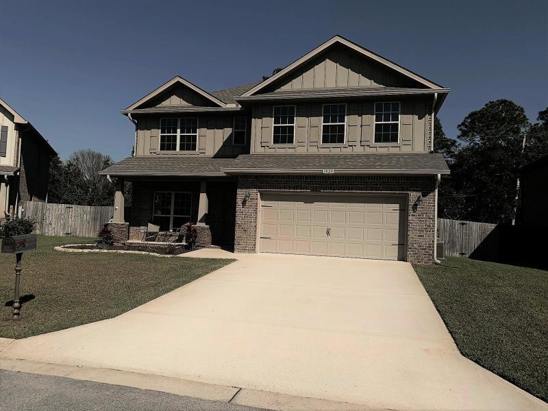 Two-story house with brick accents, a double garage, and a wide concrete driveway.