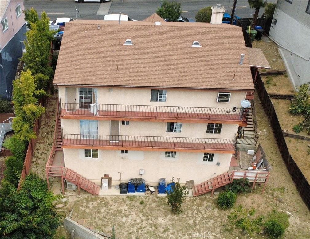 Aerial view of a multi-story apartment building with long balconies and exterior staircases.