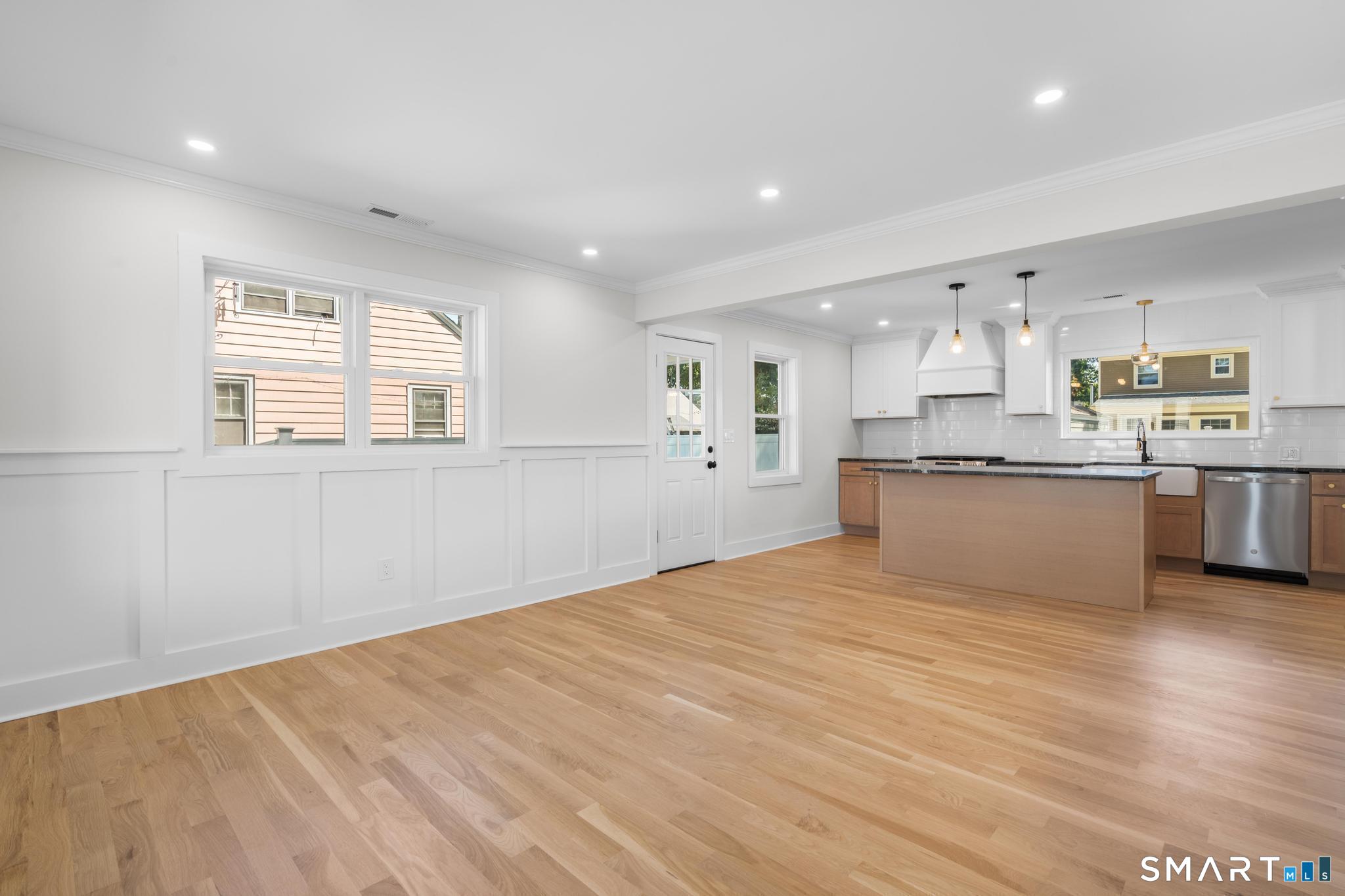 Bright kitchen with a large wood island, white cabinetry, and hardwood floors.