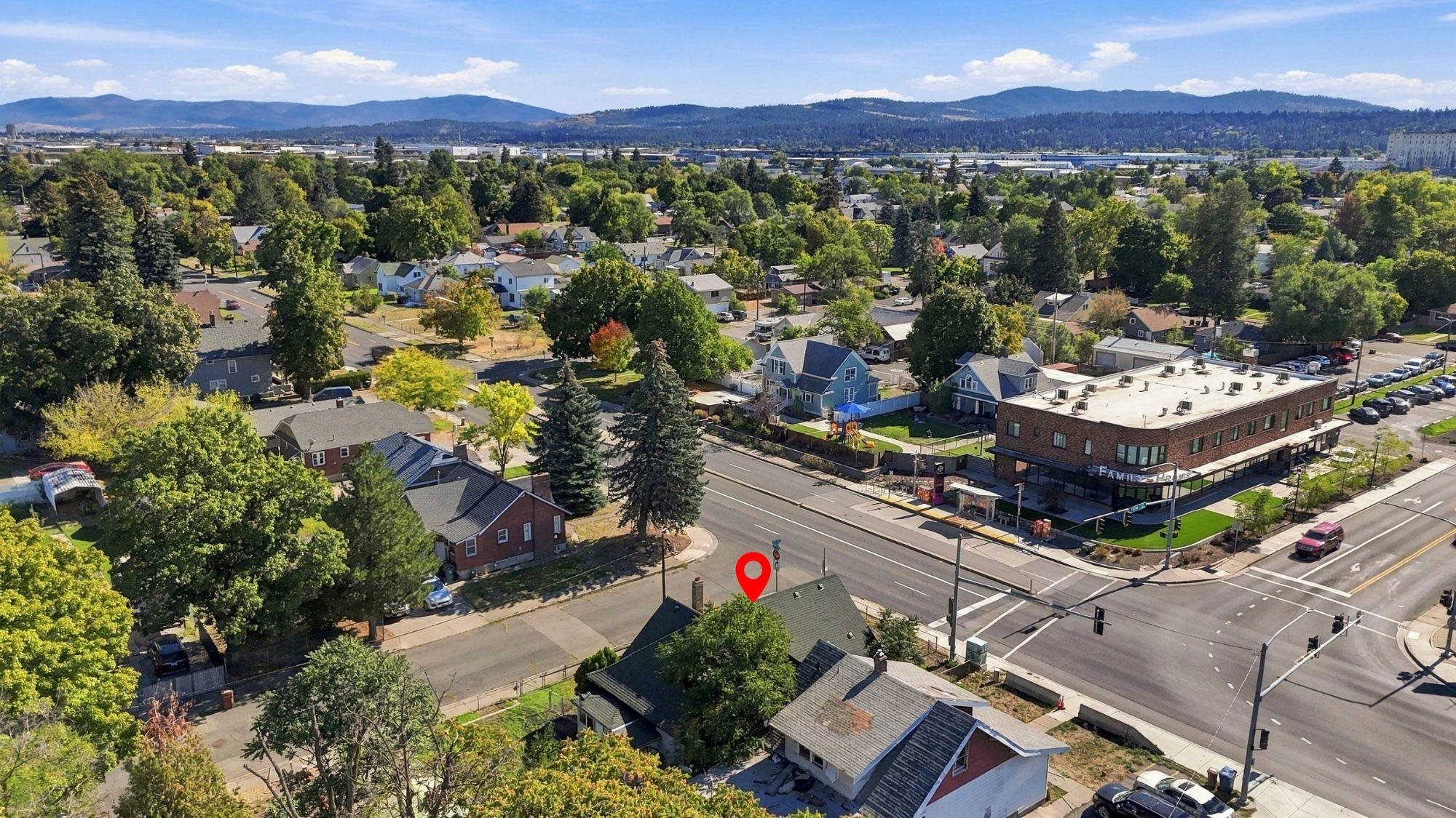 Aerial view of the property marked near a Spokane intersection, with neighborhood homes and distant mountains.