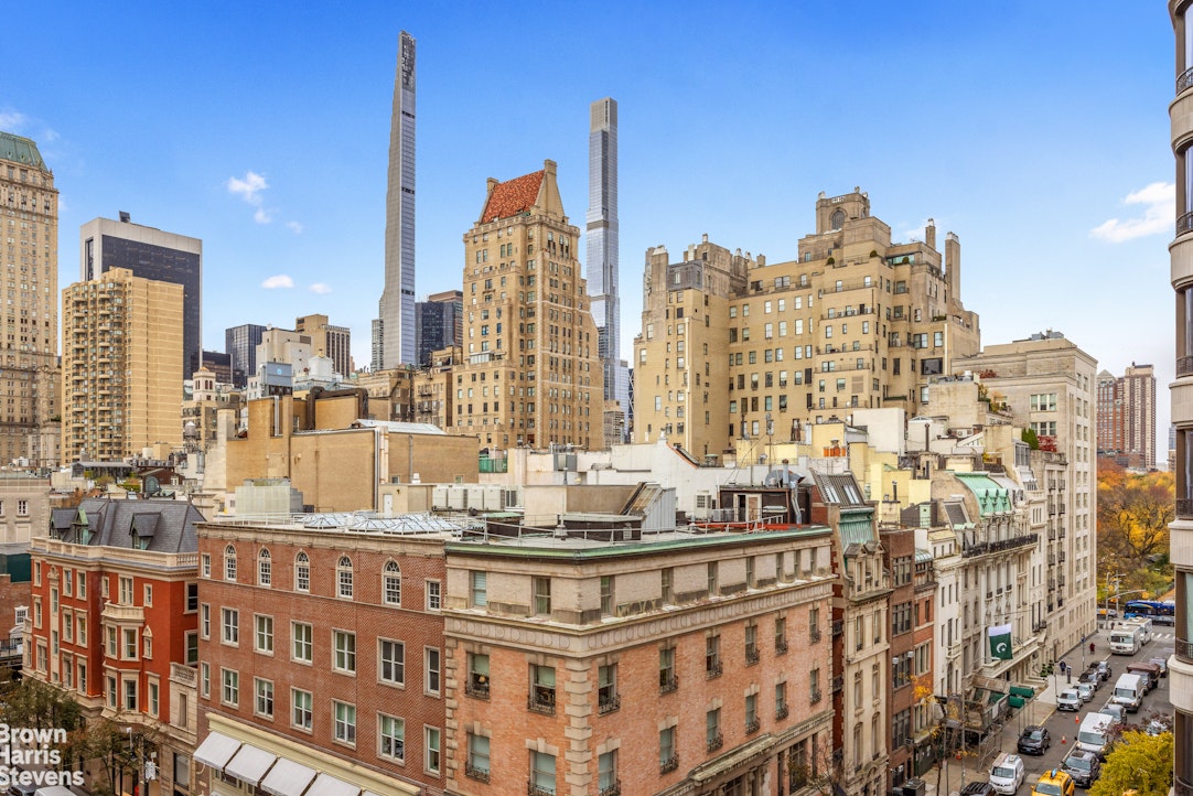 Manhattan skyline with modern skyscrapers rising above older buildings and rooftops.
