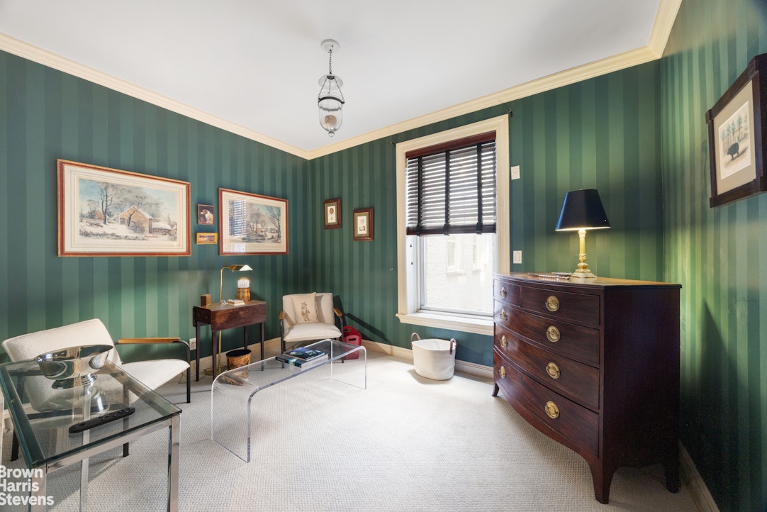 Sitting room with green striped wallpaper, a glass coffee table, and a dark wooden dresser.