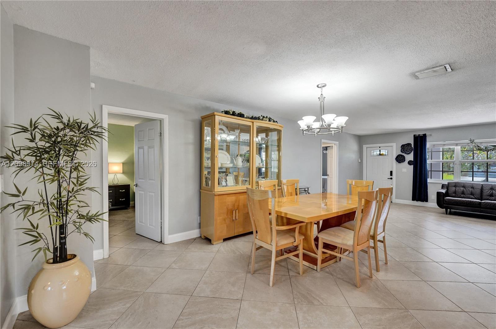 Dining area with a light wood table and glass-front china cabinet beside the living room.