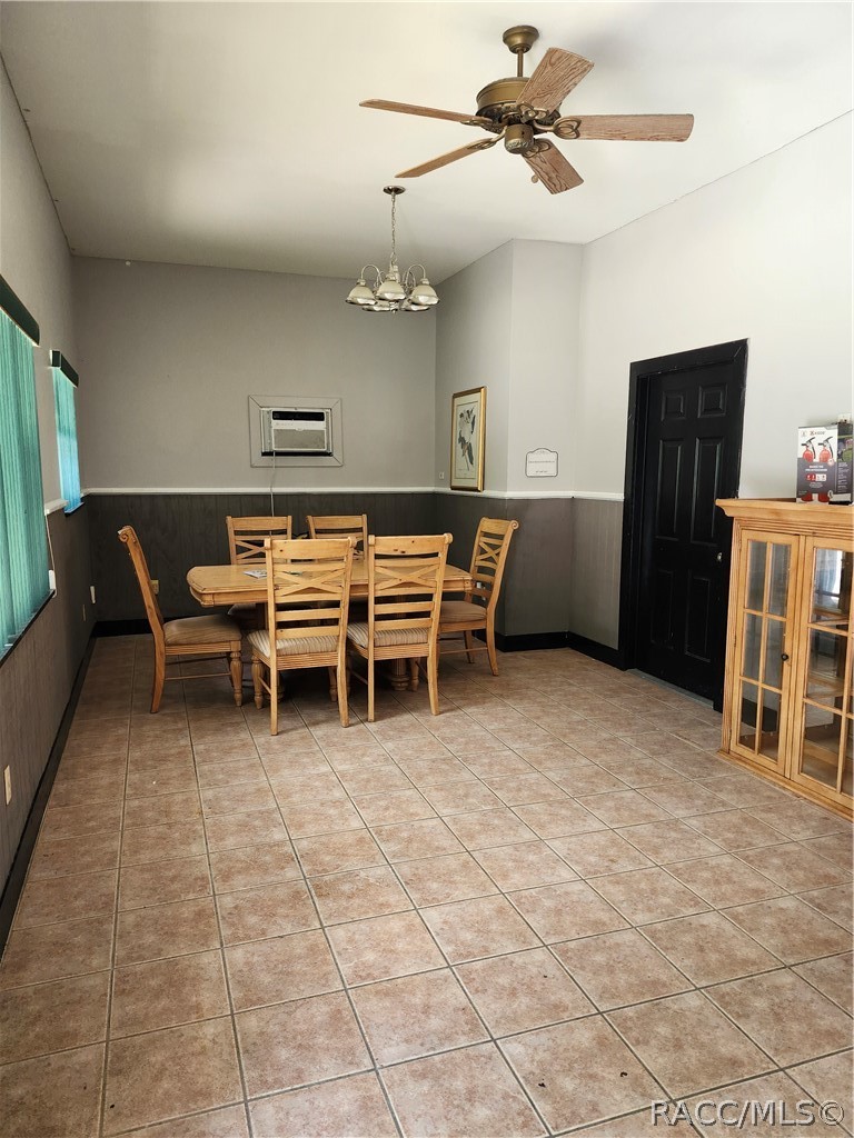 Dining room with a wooden table and chairs, tiled floor, and ceiling fan.