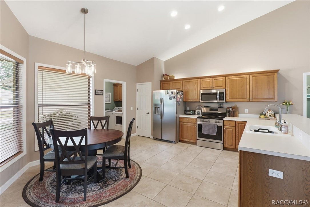 Kitchen and dining area with wood cabinets, stainless steel appliances, and a round dining table.