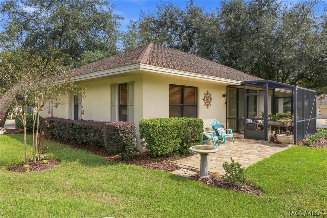 Single-story home with a screened patio, paver terrace, and landscaped lawn.