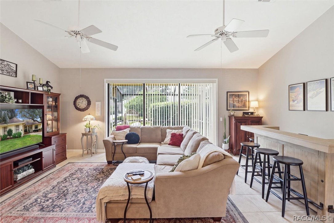 Furnished living room with a sectional sofa, breakfast bar, and sliding doors overlooking the yard.