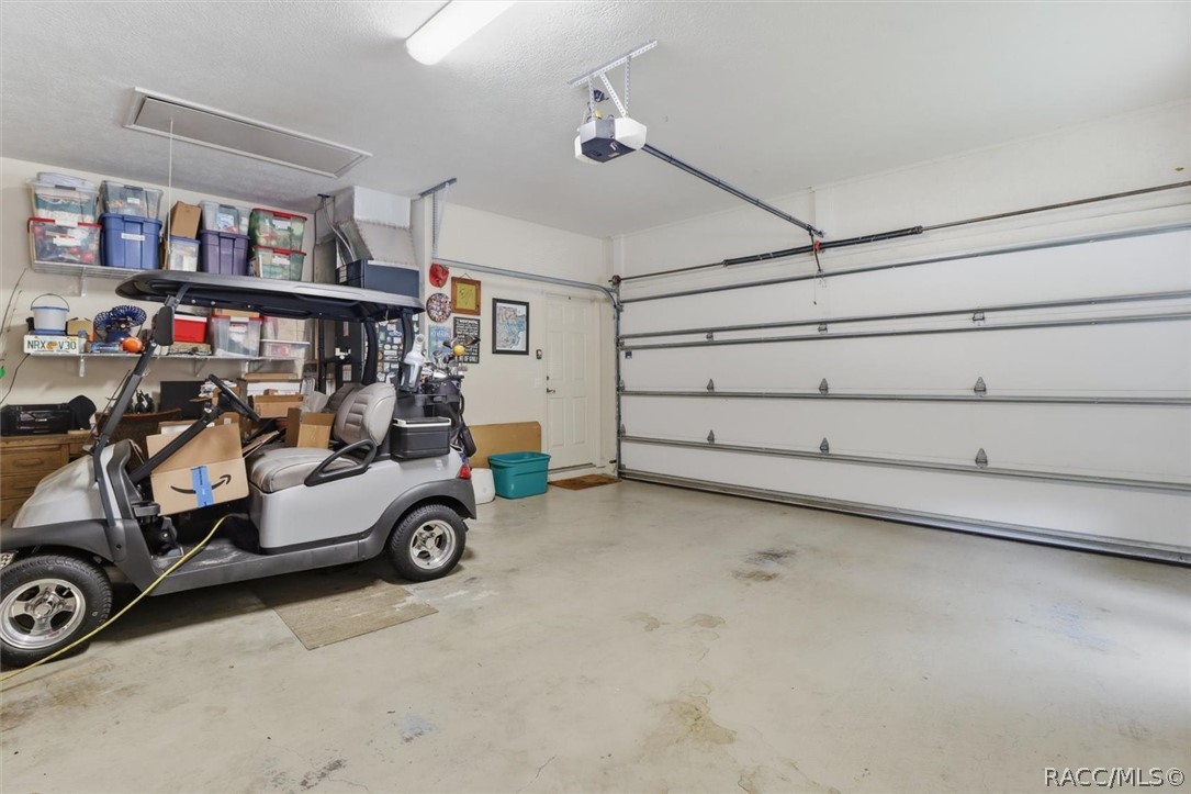 Garage with a golf cart, storage shelves, and a closed sectional garage door.