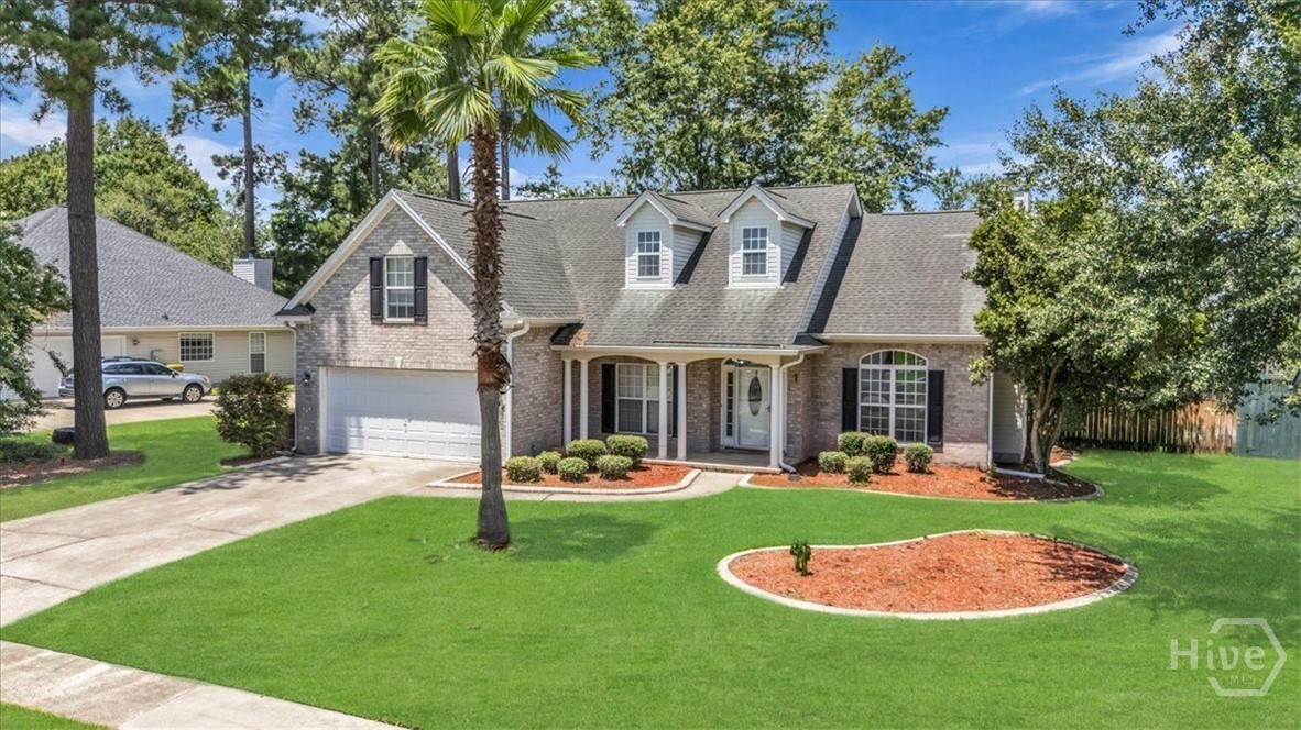 Brick two-story home with dormers, double garage, and a broad landscaped front lawn.