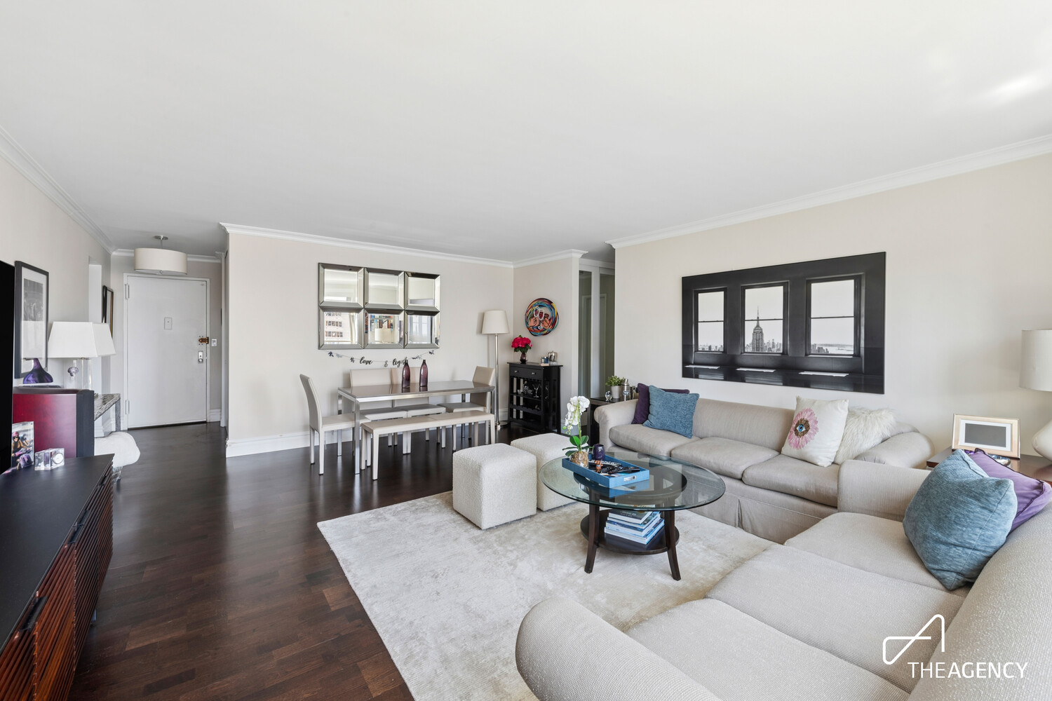 Living room with a cream sectional sofa, glass coffee table, and dining area.