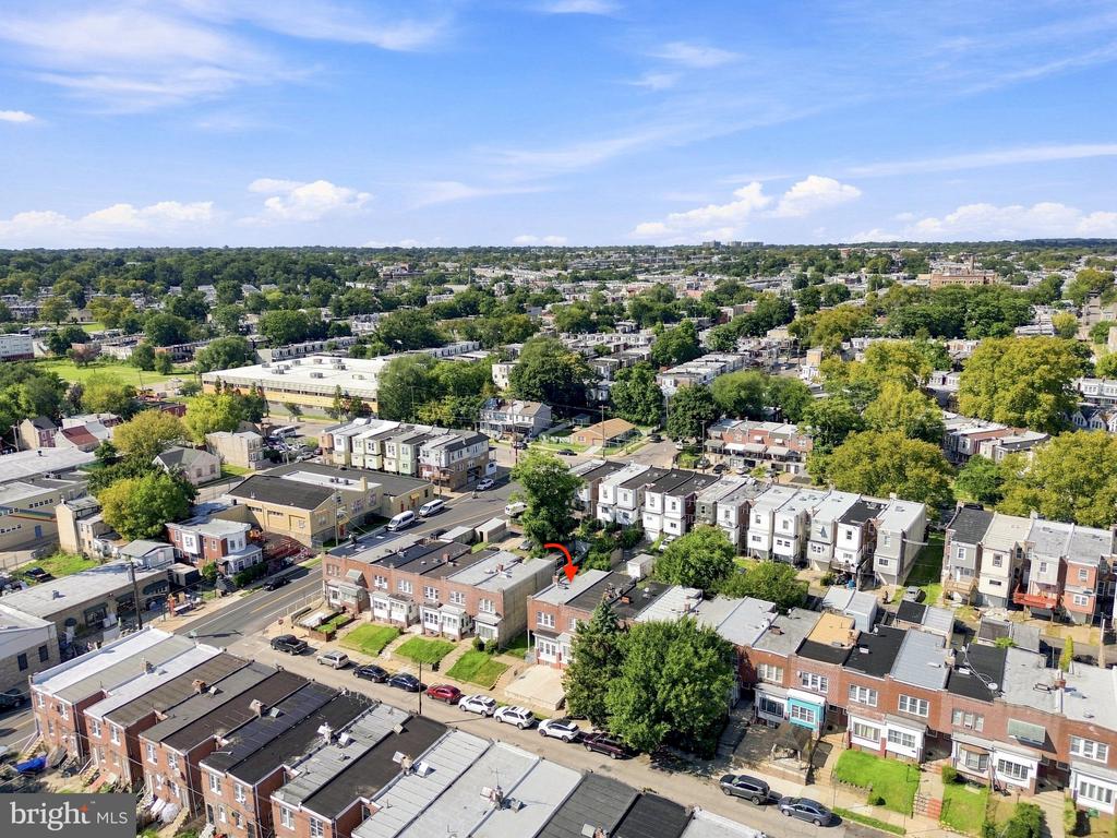 Aerial view of Philadelphia row houses and tree-lined streets, with a red arrow marking a property.