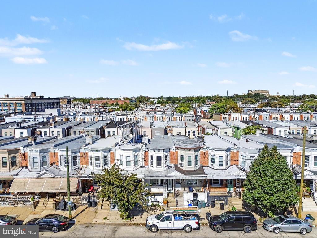 Elevated view of Philadelphia row houses along a residential street, with parked cars and leafy trees.