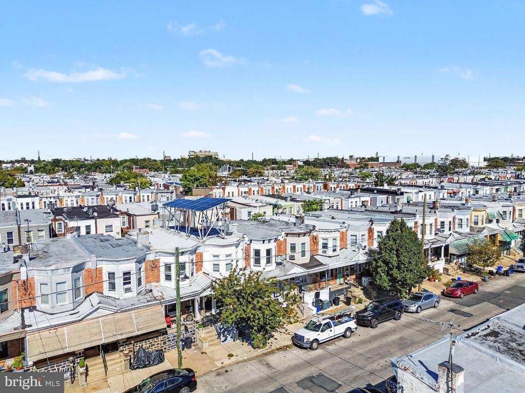 Aerial view of Philadelphia row houses with rooftop solar panels and a residential street.