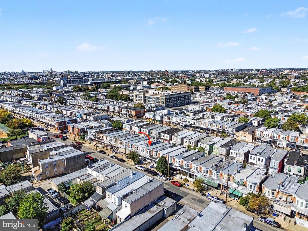 Aerial view of dense Philadelphia rowhouses, with a red arrow marking the property.