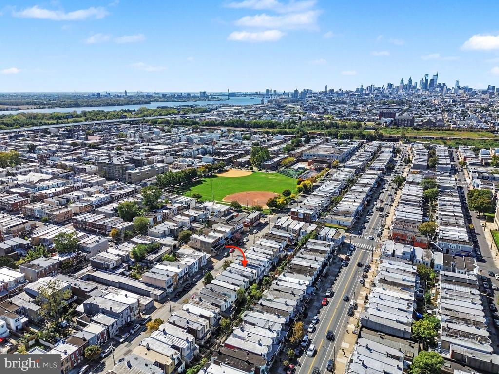 Aerial view of Philadelphia rowhouses, with a red arrow marking a home and the Center City skyline beyond.