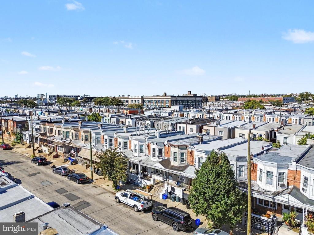 Aerial view of dense row houses and parked cars along a residential street.
