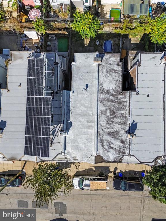 Aerial view of connected rowhouses, with solar panels covering part of one rooftop.
