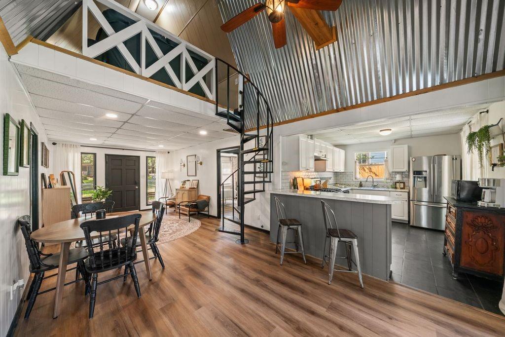 Open-concept living, dining, and kitchen area with a spiral staircase and loft.