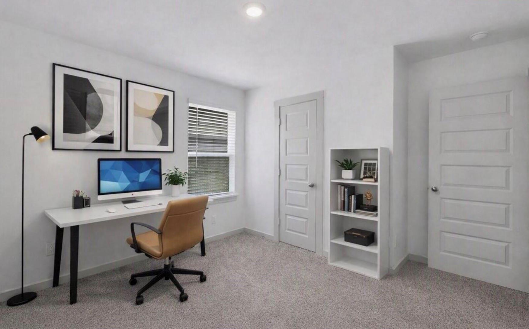 Home office with a white desk, tan swivel chair, window blinds, and small bookcase.
