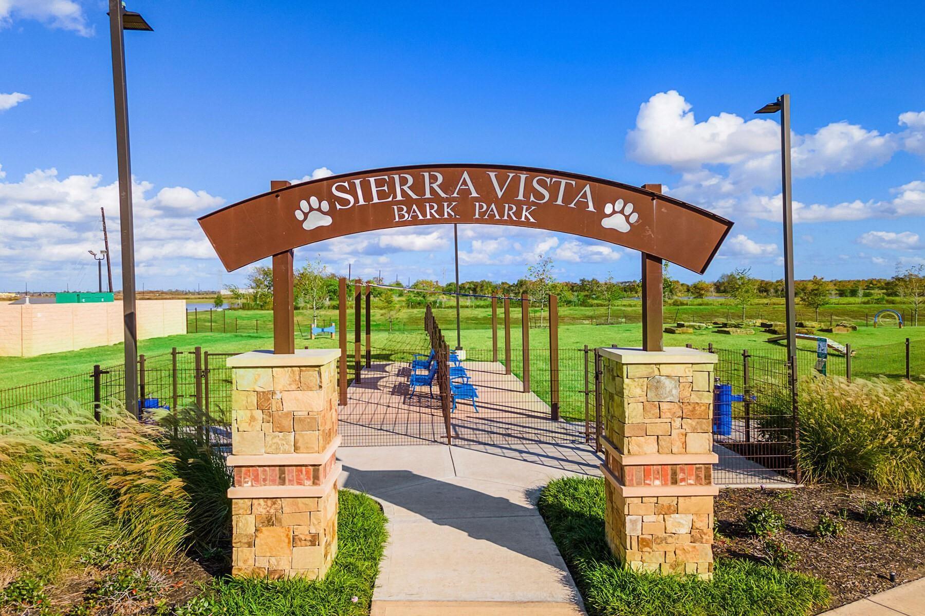 Sierra Vista Bark Park entrance with stone pillars and a paved path into the fenced park.