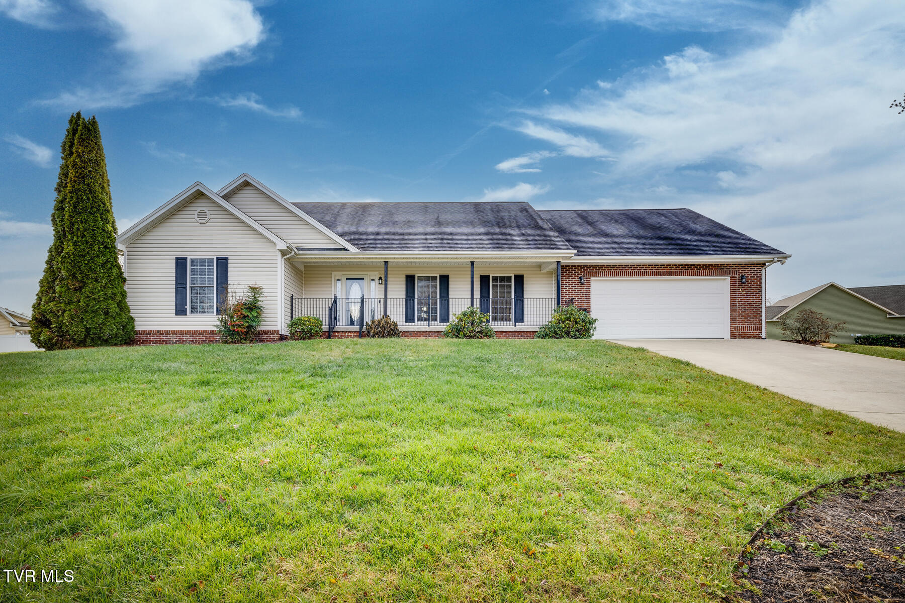 Single-story home with a covered porch, brick accents, and an attached garage.