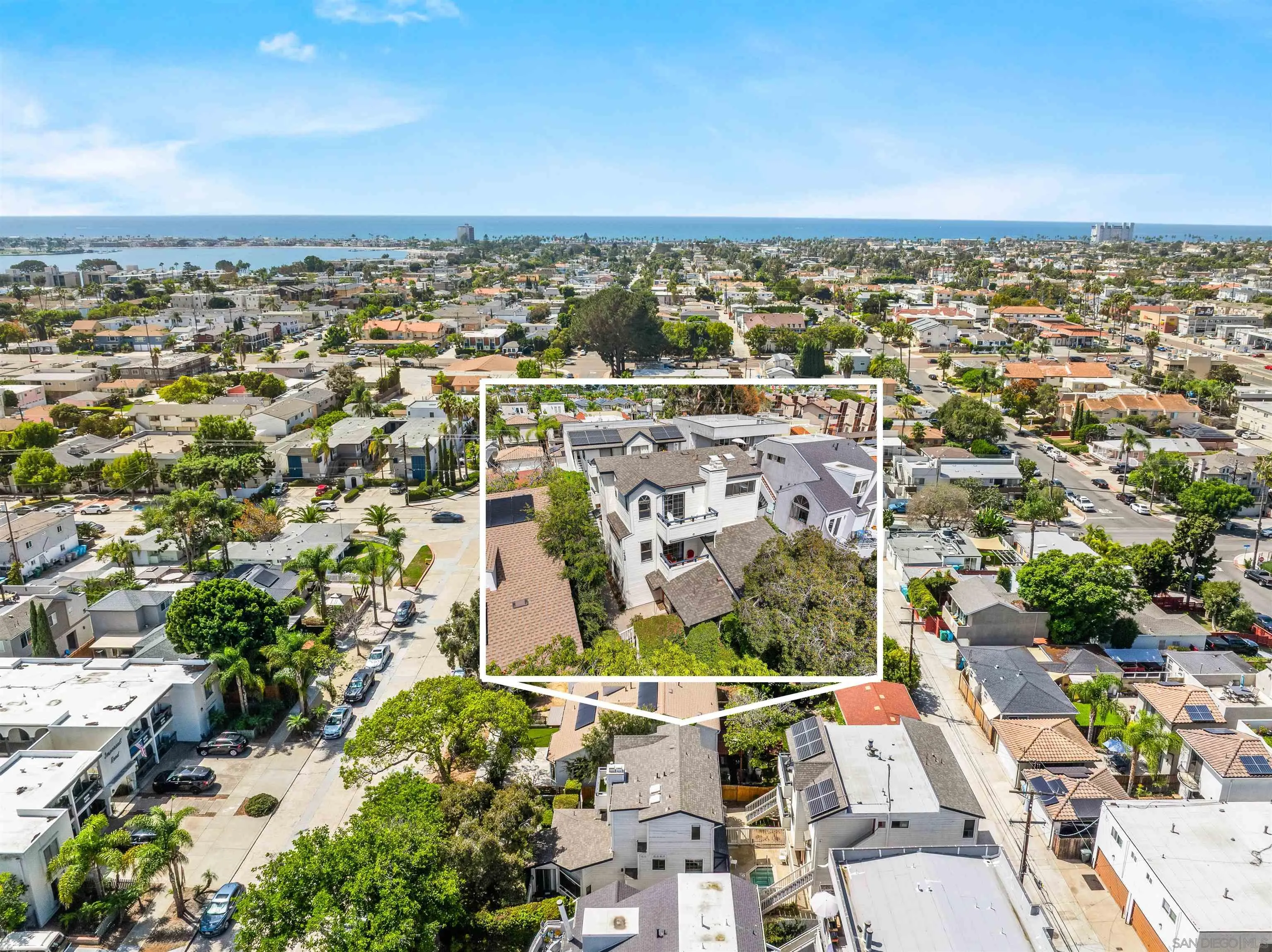 Aerial view of Pacific Beach homes, with a featured house outlined and ocean on the horizon.