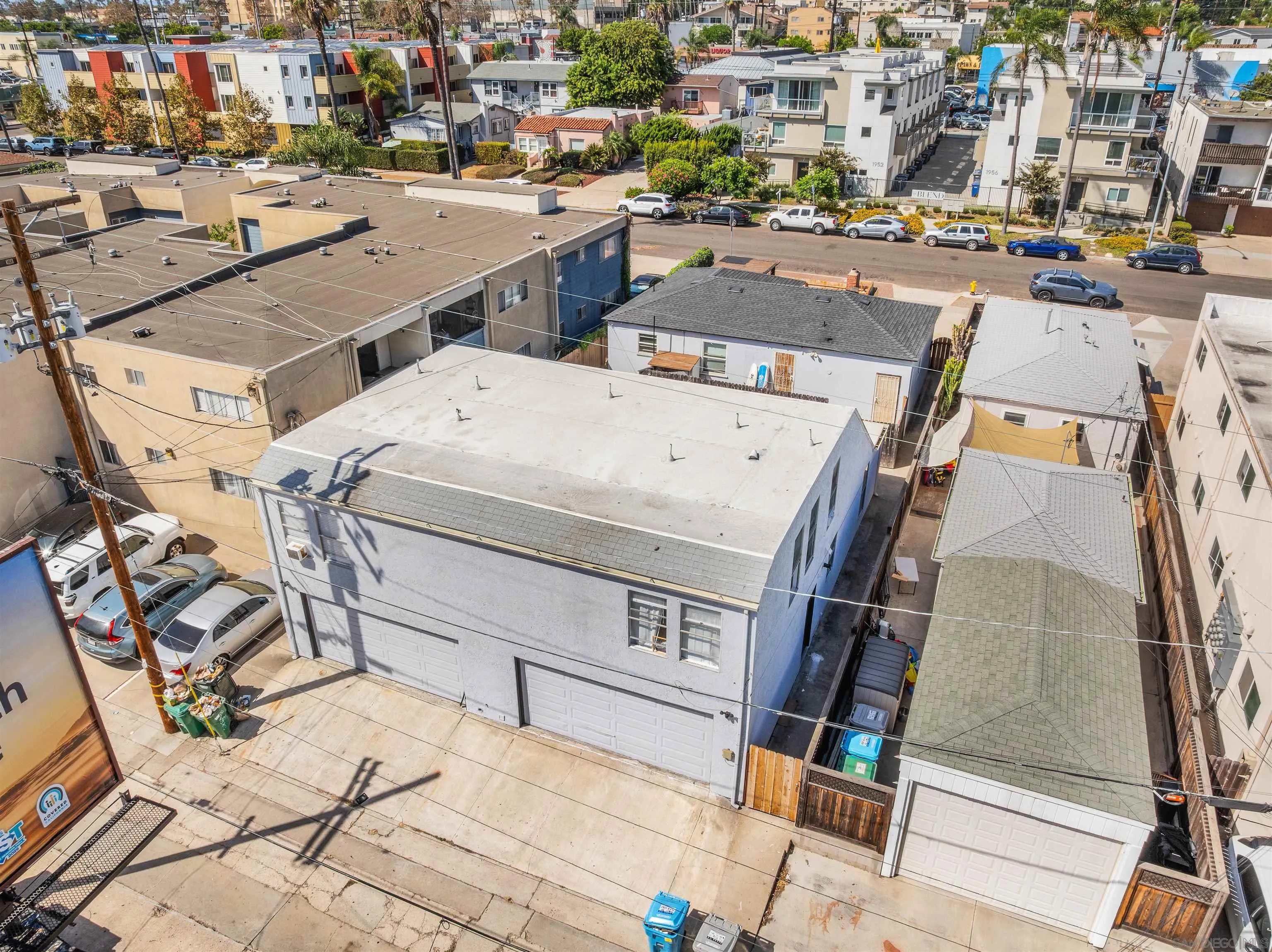Aerial view of apartment buildings with flat roofs, garages, and a densely built neighborhood.