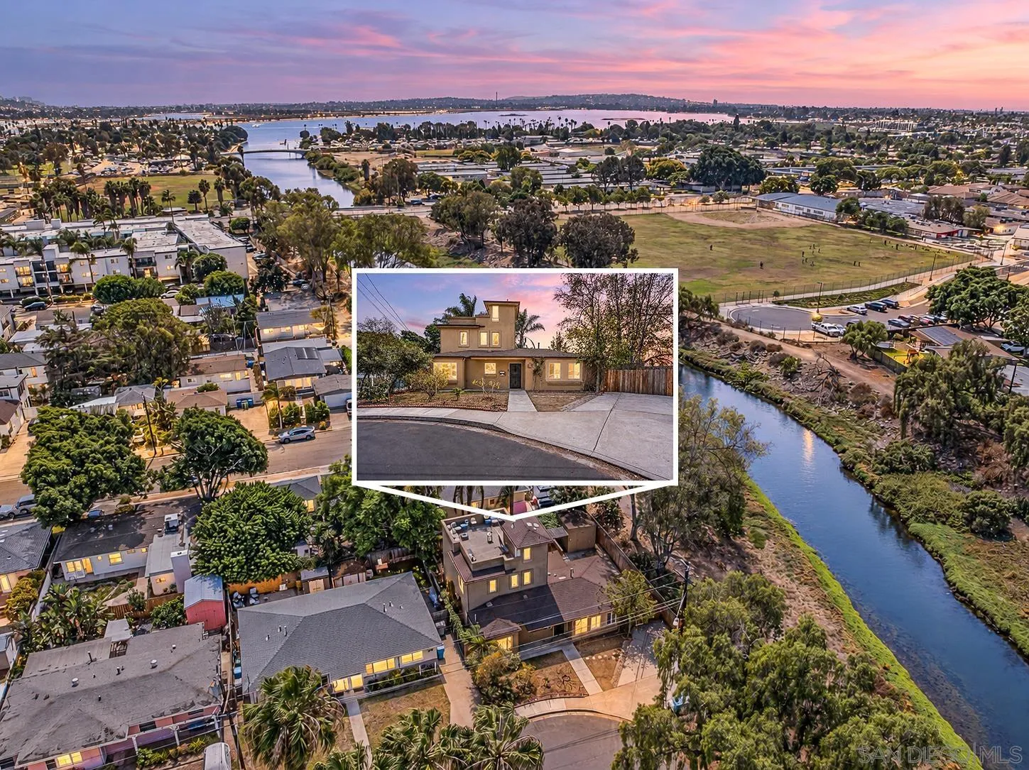 Aerial view of homes beside a waterway at dusk, with a featured two-story house inset.
