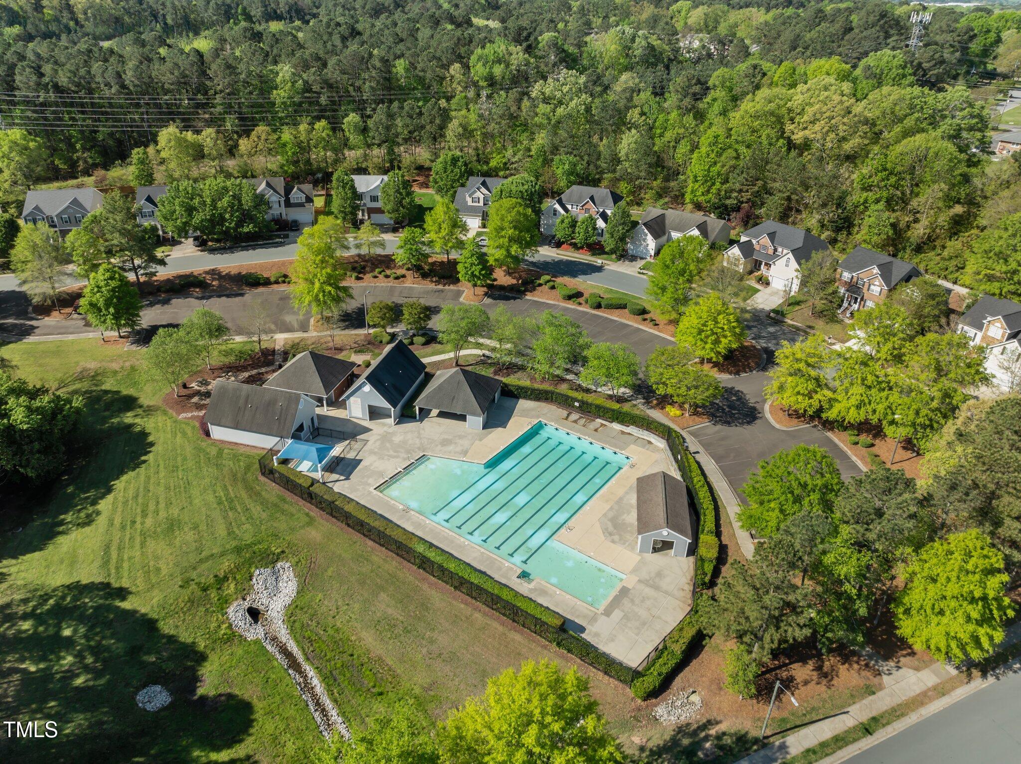Aerial view of a neighborhood pool with lap lanes, a shallow pool, and surrounding homes.