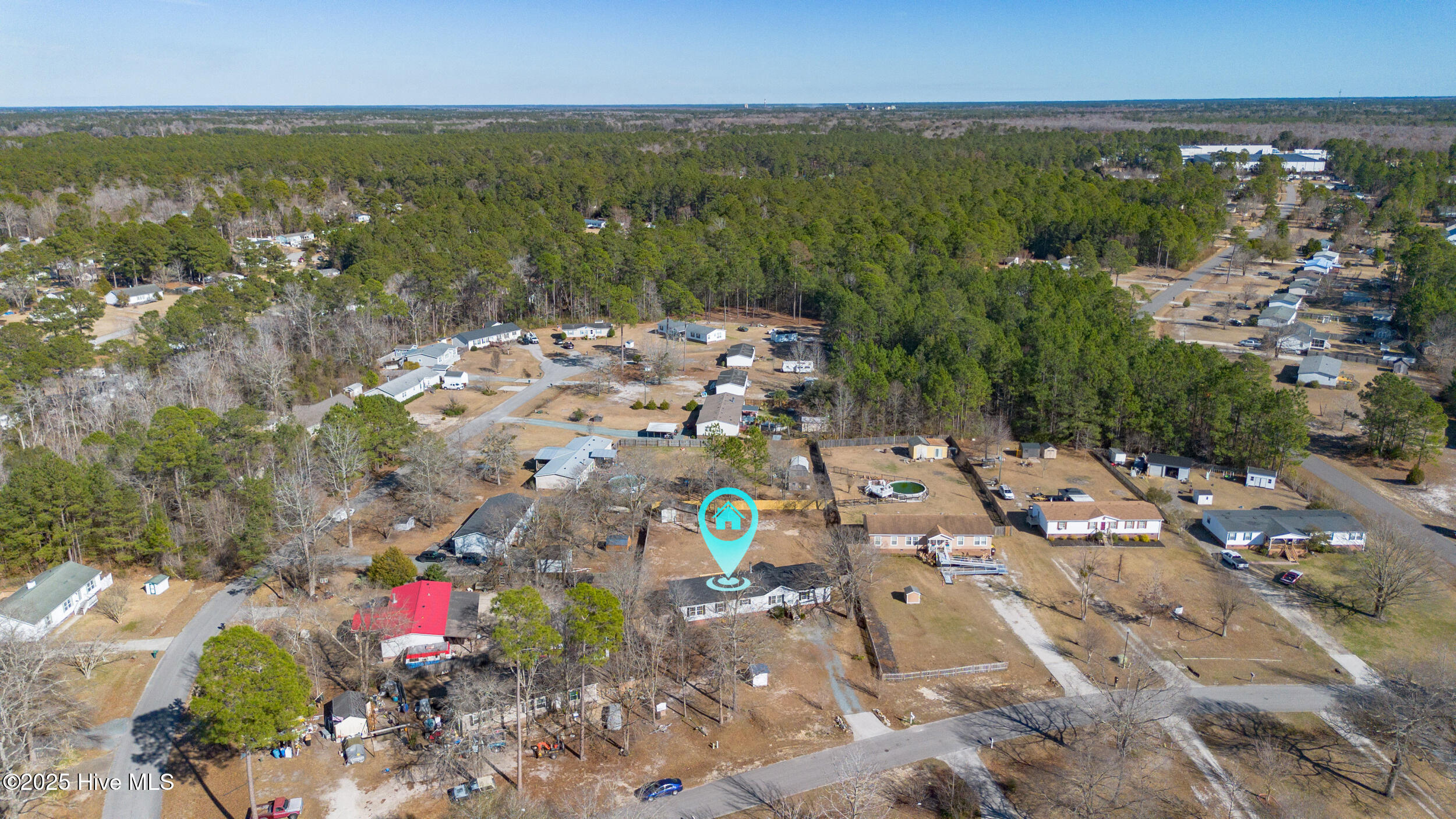 Aerial view of 606 Ardmore Road, marked by a turquoise pin among neighboring homes and surrounding woods.