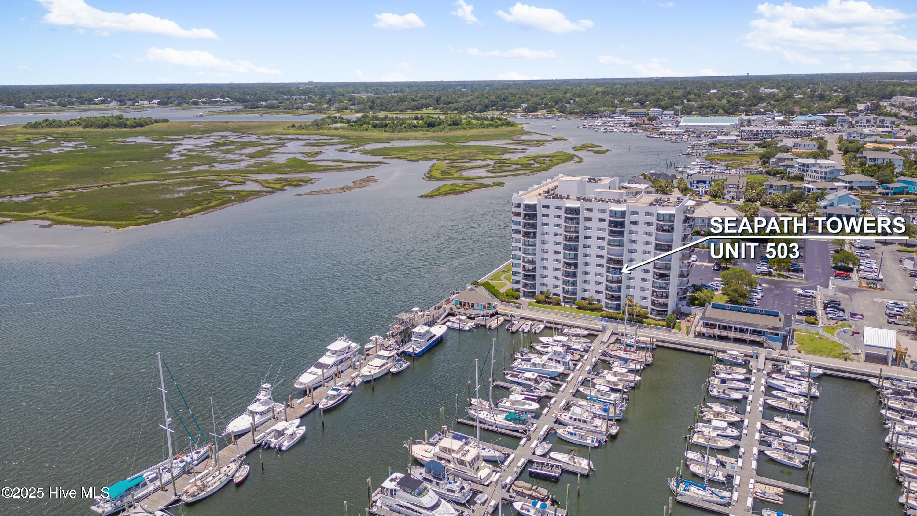 Aerial view of Seapath Towers unit 503 beside a marina, inlet, and marsh.