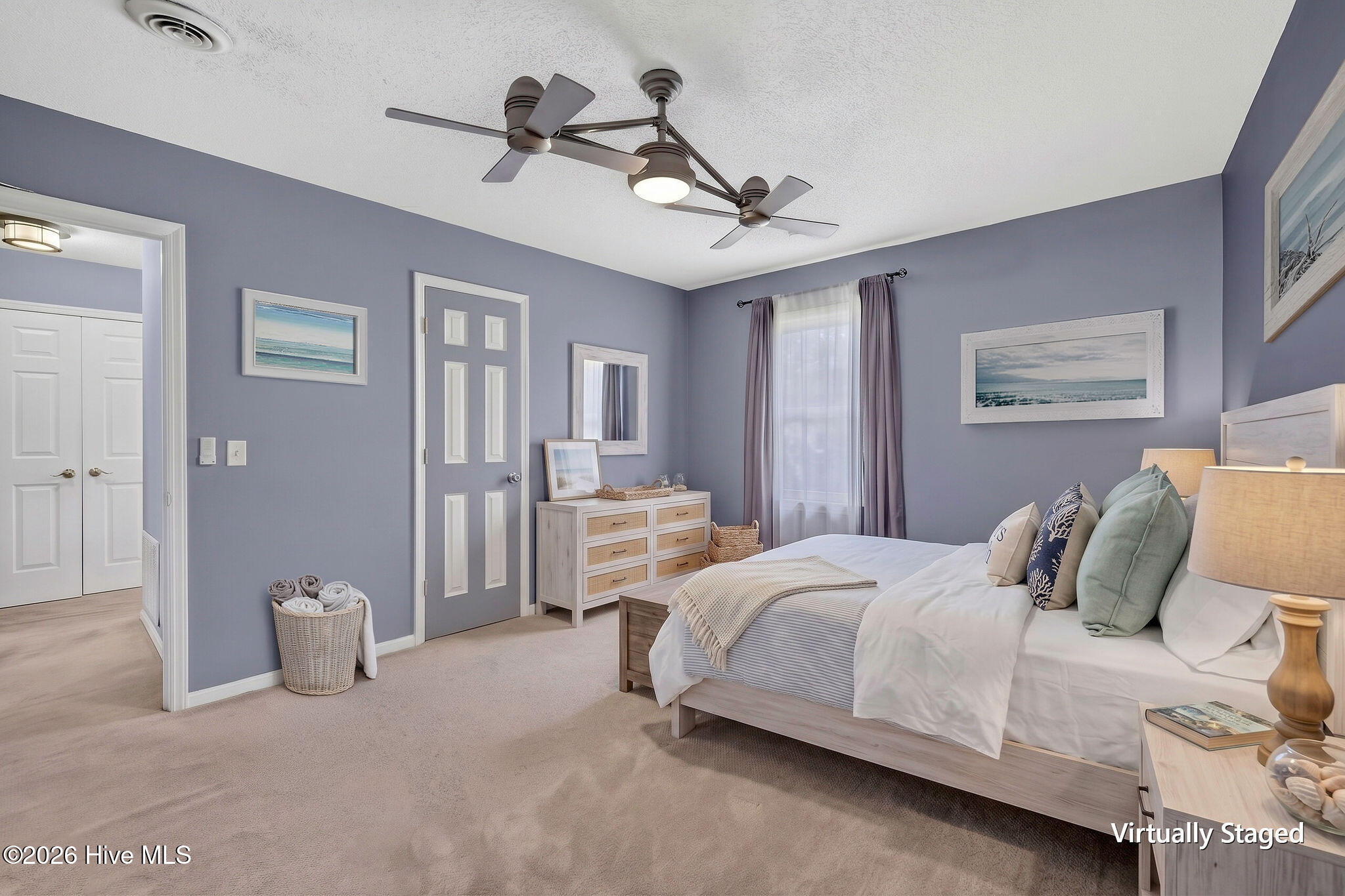 Virtually staged bedroom with a light wood bed, lavender-gray walls, and a ceiling fan.