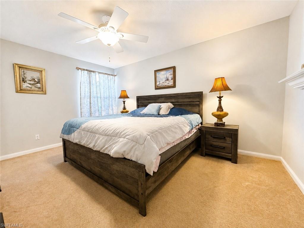 Furnished bedroom with a large dark wood bed, blue-and-white bedding, and beige carpet.