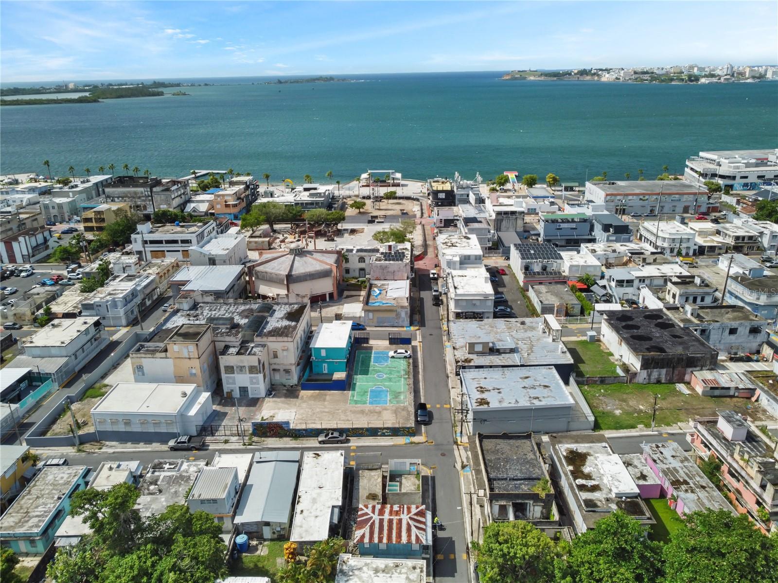 Coastal neighborhood beside a bay, with a small outdoor sports court.