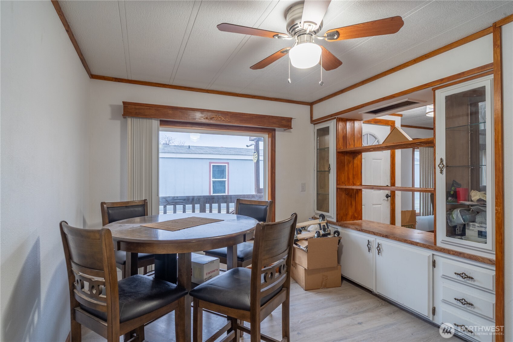 Dining room with a round wood table, built-in cabinetry, and a sliding glass door to a deck.