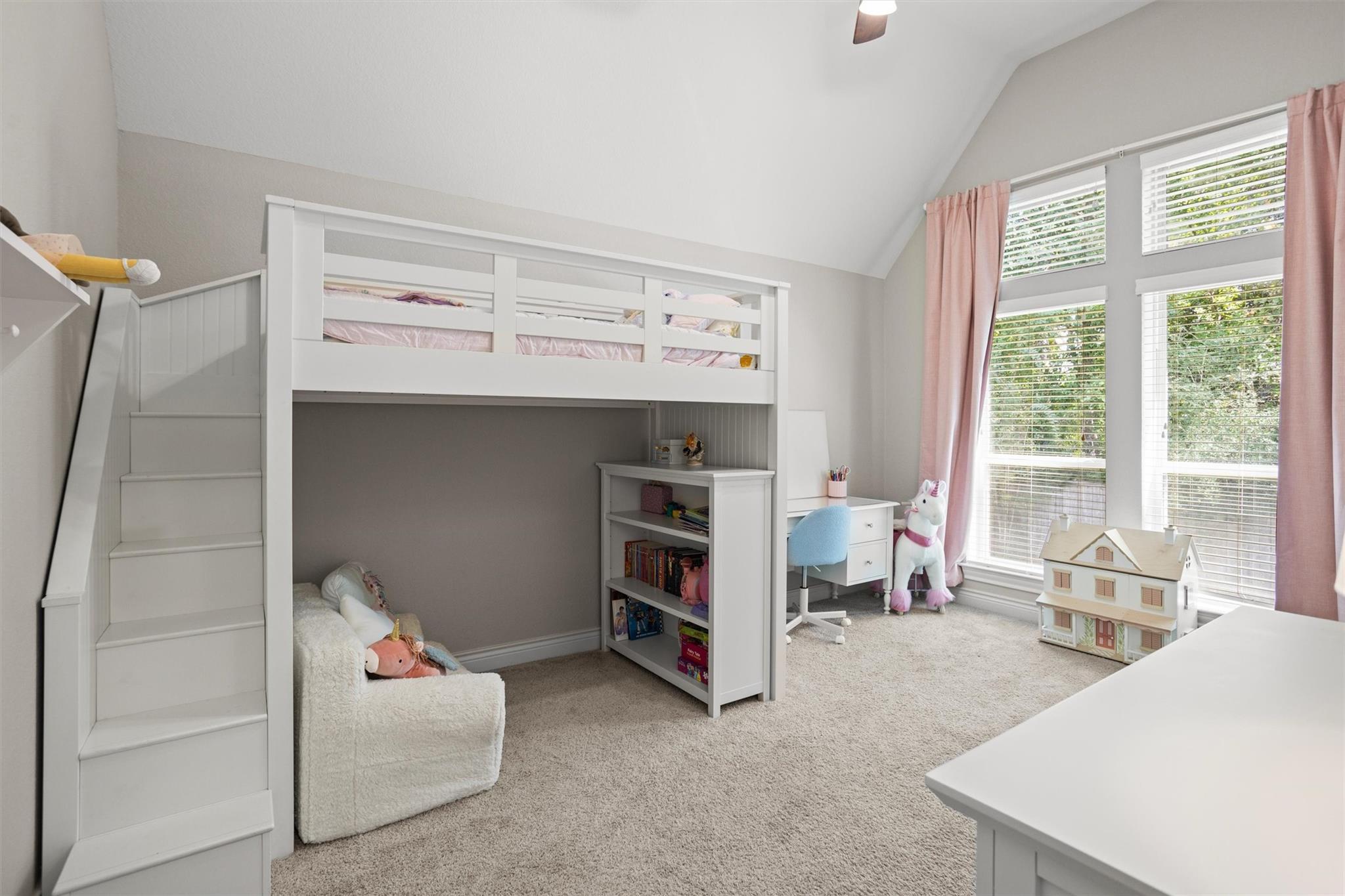 Children’s bedroom with a white loft bunk bed, built-in stairs, desk, and tall windows.