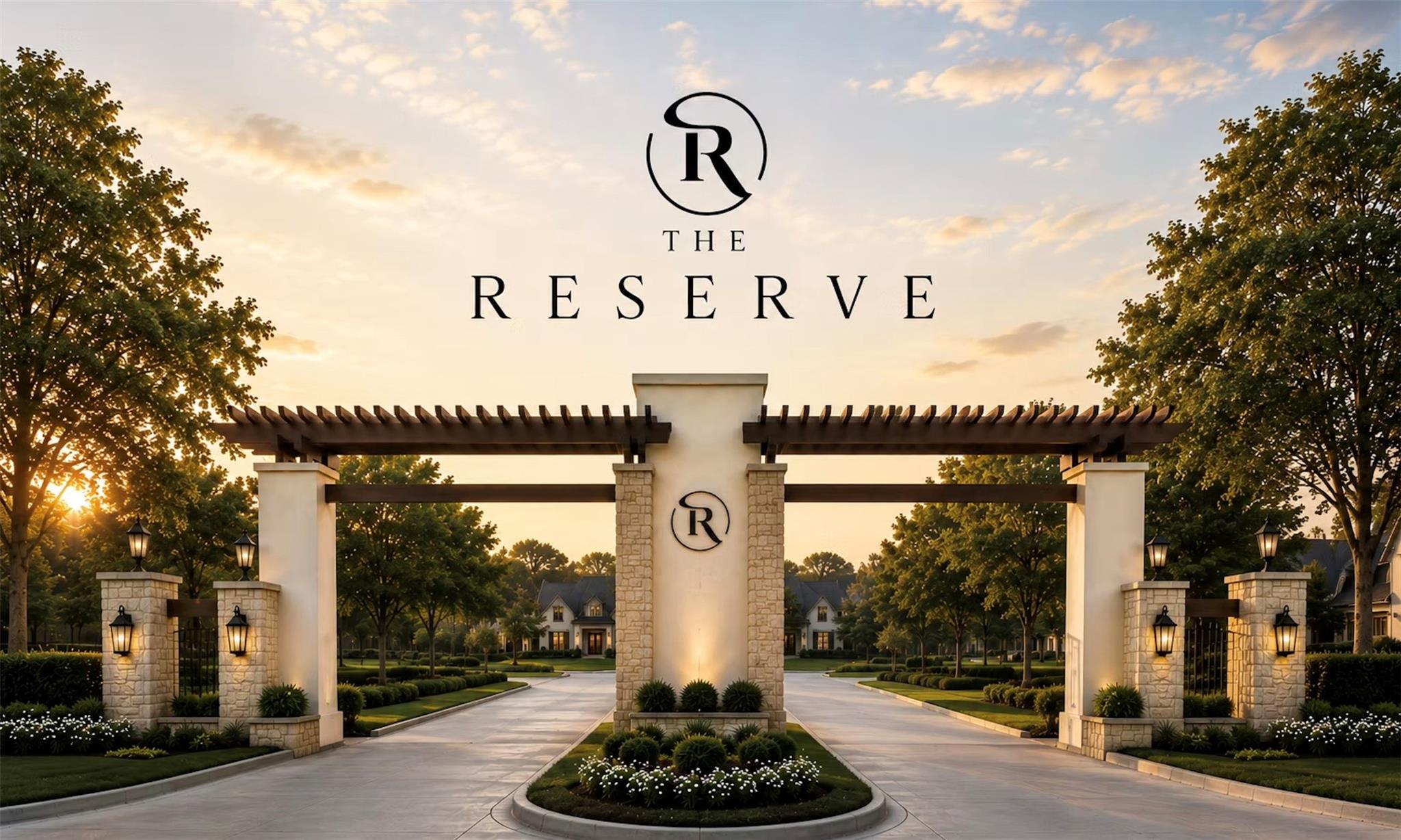 The Reserve community entrance with stone pillars, a timber pergola, and a landscaped drive at sunset.