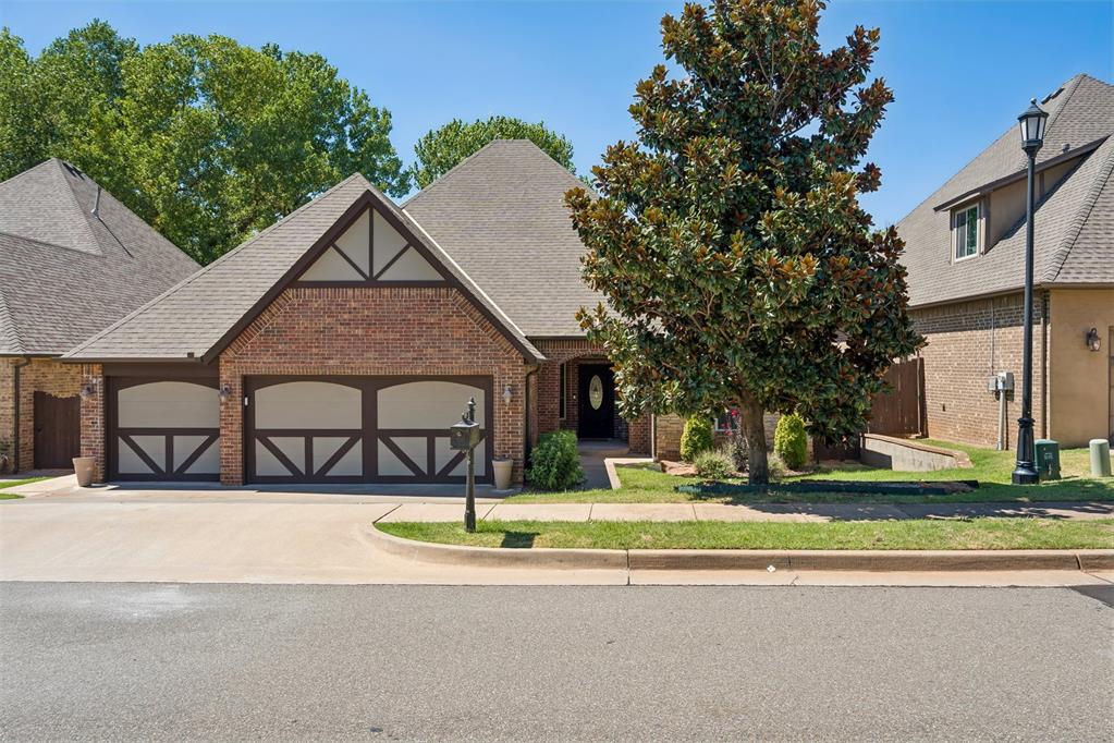 Brick house with a two-car garage and large magnolia tree in the front yard.