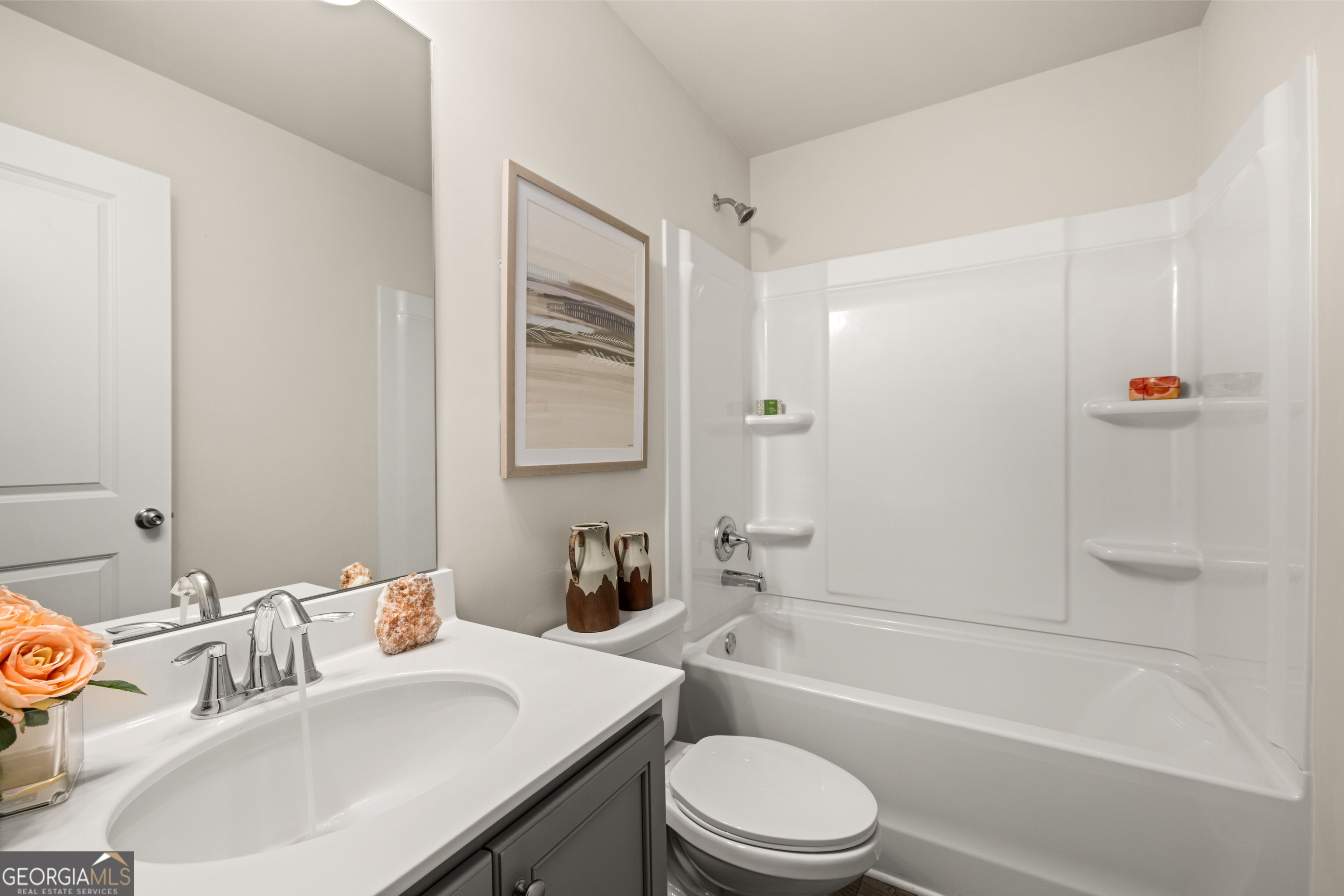 Bathroom with a gray vanity, white sink, and tub-shower combination.