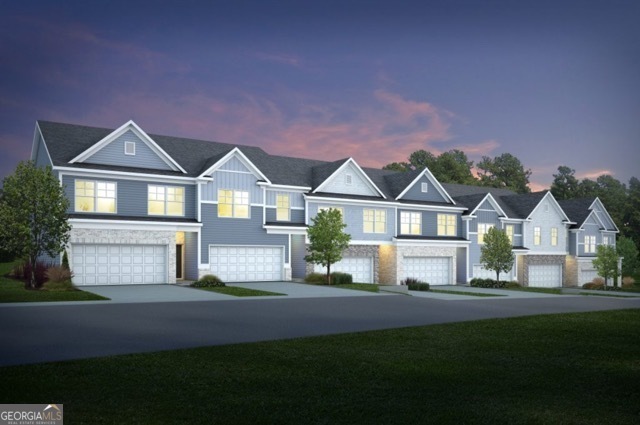 Row of blue-gray attached homes with lit windows and garages beneath a pink dusk sky.